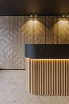 an elegant reception area with black and white marble counter top, wood paneling and lights