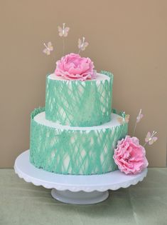 a three tiered cake with pink flowers on top