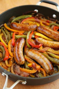 sausages and peppers cooking in a skillet