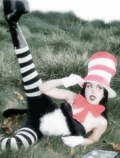 a woman laying on the ground wearing a cat in the hat costume with her legs spread out