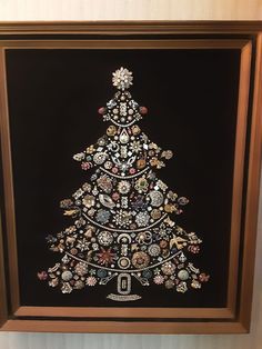 a christmas tree made out of buttons on a black background in a brown framed frame