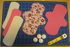 sewing supplies laid out on a cutting board with scissors and paper machs next to them