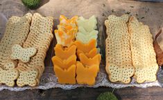 crackers and cheeses are arranged on a lace doily with grass in the background