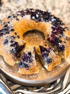 a blueberry bunt cake on a plate with powdered sugar