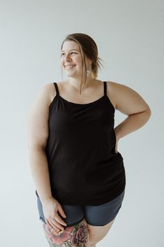 Introducing our Basic Layering Cami, the must-have piece for your wardrobe. Adjustable straps, scooped neckline, and tunic length make it perfect for layering under any outfit. With a slim fit and available in plus sizes, it's a versatile addition to any look. Don't just take our word for it, try it in every color! Fits true to size. We suggest going with your typical size. The cami is intended to be fitted. If you would like it to fit loose, we suggest going up one size. Leslie is wearing a siz Black Camisole With Built-in Bra For Layering, Black Tank Top With Wide Adjustable Straps, Black Stretch Tank Top With Wide Straps, Versatile Solid Color Scoop Neck Camisole, Versatile Stretch Black Camisole, Black Tank Top With Built-in Bra For Loungewear, Versatile Everyday Camisole With Scoop Neck, Versatile Scoop Neck Camisole For Everyday, Versatile Black Scoop Neck Top