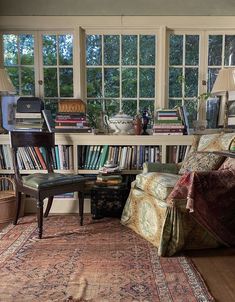 a living room filled with lots of furniture and bookshelves next to a window