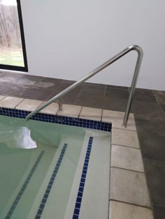 an empty swimming pool with stairs leading up to the water's edge and tiled floor