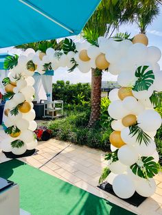 an arch made out of balloons and palm trees