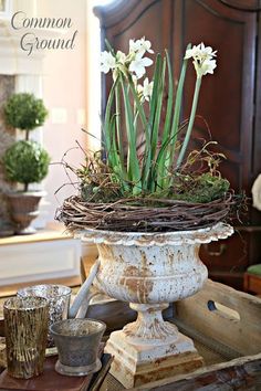 a white vase filled with flowers sitting on top of a table