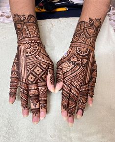 two hands with henna designs on them