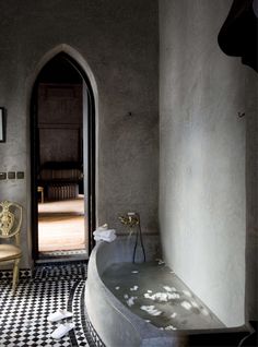 a bathtub in the middle of a room with a checkered floor and walls