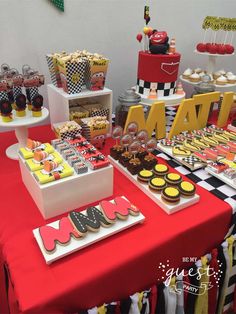 a red table topped with lots of cakes and cupcakes