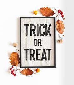 a trick or treat sign surrounded by autumn leaves and acorns on a white background