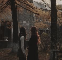 two women standing in the woods looking at each other