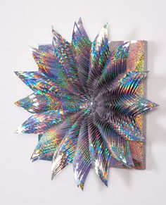 an abstract art piece with multicolored petals on a white background, in the shape of a star