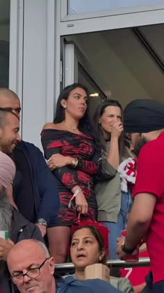 a group of people standing next to each other in front of a window at a sporting event