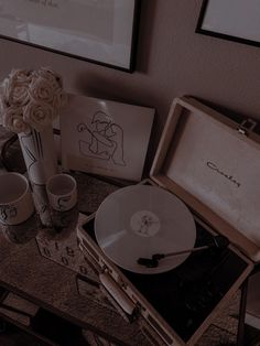 an old record player and two cups on a table