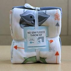 two baby swaddles wrapped in white and blue with an arrow design on them