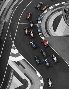 an aerial view of a race track with cars driving around the corner and on top of each other