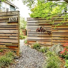 two wooden gates with numbers on them in the middle of some plants and flowers around