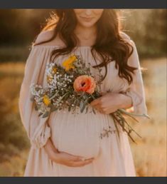 a pregnant woman holding flowers in her belly