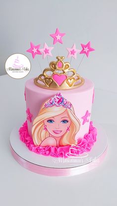 a birthday cake with a barbie doll on top and pink icing, surrounded by stars