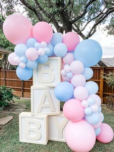 the balloon arch is decorated with pink, blue and white balloons for a baby's first birthday