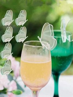 a wine glass filled with liquid and butterflies