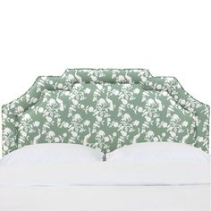 an upholstered headboard with white and green floral designs on it, against a white background