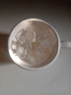 a cup filled with ice sitting on top of a table