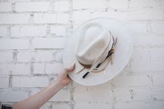 Our love of hats just got became a full-on obsession: meet the Navajo Feather Banded Hat in Ivory. The most chic, high-end hat we could've ever dreamed up. A hat this good needs to be worn as much as possible and with every single outfit! Hand made by artisans, incredible quality, pure suede, genuine leather trim around the crown, authentic feathers, chain, too many details to list! The best part? It's super structured with an elastic band on the inside that will fit EVERYONE. Btw never taking t White Fedora With Flat Crown For Country Events, White Flat Crown Hat For Western-themed Events, White Southwestern Short Brim Hat, White Bohemian Panama Hat With Flat Brim, White Bohemian Felt Hat For Rodeo, White Artisan Fedora For Rodeo, White Artisan Style Fedora For Rodeo, White Flat Brim Straw Hat For Festivals, White Bohemian Fedora Felt Hat