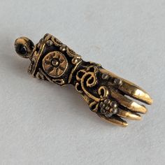 This gorgeous glove charm is highly ornate with exquisite details -- maybe baroque in style? The charm is perfect for a bracelet or necklace and brings to mind Victorian gloved ladies seeking out suitors at a ball. I'm not certain how many carats the gold is, but from researching, I believe it to be 14 or 18ct. It is possible that these are metal gold plated/coated. Measures approximately 7/8" in length I have NOT attempted to clean it as I do not want to damage the integrity of the piece. Free Ornate Pendant Jewelry With Charms, Victorian Gold Jewelry With Charms, Ornate Bronze Jewelry With Vintage Charm, Antique Hand Cast Gold Jewelry, Antique Gold Hand Cast Jewelry, Antique Hand-cast Gold Jewelry, Elegant Bronze Jewelry With Charms, Victorian Metal Jewelry With Charms, Victorian Metal Jewelry With Lobster Clasp