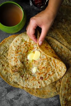 a person dipping butter on top of some flatbreads