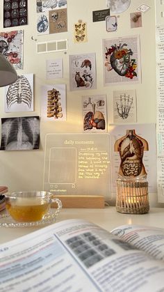 an open book sitting on top of a table next to a glass cup filled with tea