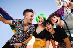 four people are posing for the camera with their arms around each other and one person has green hair