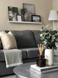 a living room with a couch, coffee table and pictures on the wall above it