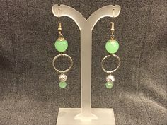 Spring green beads glow in the light and connect to a silver loop for a modern, yet elegant look. Elegant Light Green Drop Earrings, Nickel-free Green Earrings For Party, Green Nickel-free Party Earrings, Adjustable Elegant Lime Green Jewelry, Elegant Green Dangle Beaded Earrings, Elegant Green Beaded Hoop Earrings, Green Metal Jewelry With Silver Beads, Nickel-free Green Beaded Earrings For Parties, Elegant Green Earrings With Faceted Beads