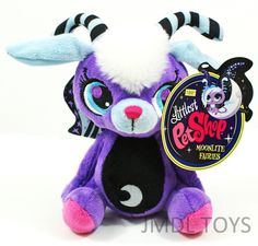 a purple stuffed animal with black and white stripes on it's head, holding a tag