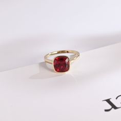 Gold Ruby Ring With Round Stone, Fine Jewelry, Gold Crystal Ring With Bezel Setting As Gift, Gold Ruby Birthstone Ring With Bezel Setting, Gold Ruby Ring With Bezel Setting, Open Design, Gold Ruby Ring With Bezel Setting, Open Ring, Formal Gold Ruby Ring With Round Stone, Classic Gold Crystal Ring With Birthstone, Gold Crystal Ring With Round Cut And Accent Stones, Gold Ruby Birthstone Ring Round Cut