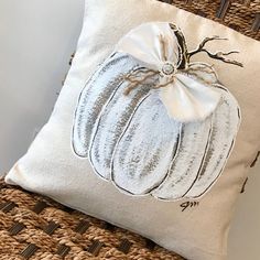 a decorative pillow with a white pumpkin on it