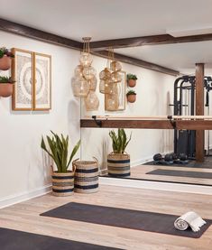 an exercise room with yoga mats and plants