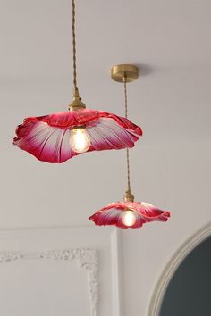 two pink flower lights hanging from a ceiling