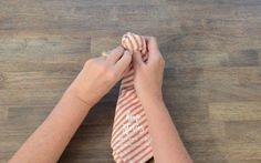 a person tying a tie on top of a wooden table