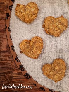 three heart shaped cookies sitting on top of a table next to a sign that says easy homemade dog treats