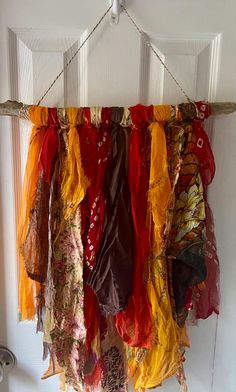 several scarves hanging from a hook on a door