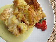 a white plate topped with fruit and pastry next to a strawberries on the side