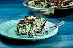 a piece of cake on a plate with a fork in front of it and another pie behind it