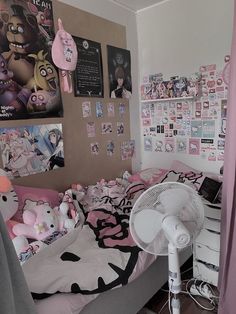 a bed room with a fan and pictures on the wall