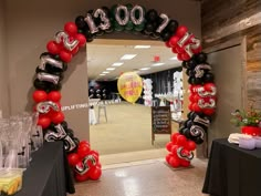 a balloon arch decorated with black, red and white balloons in the shape of numbers