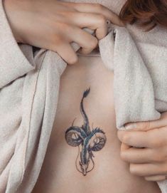 a woman's stomach with a tattoo on her side and an animal head in the middle